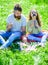 Dad and daughter sits on grass at grassplot, green background. Child and father posing with eyeglases and muastache