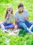 Dad and daughter sits on grass at grassplot, green background. Child and father posing with eyeglases and muastache