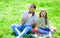 Dad and daughter sits on grass at grassplot, green background. Child and father posing with eyeglases and mustache photo