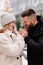 Dad and daughter walk winter streets and warms her hands with breath.