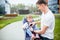 Dad fastens his daughter`s seat belts before riding a bike.