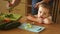 Dad feeds her daughter. The little girl does not want to eat broccoli. She gets angry and turns away.