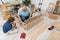 Dad fits the shelves together and son waits with the screwdriver.