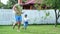 Dad with a four-year-old son playing ball, football, in the yard on a green lawn, in the summer.