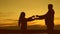 Dad gives his little daughter a heart symbol at sunset. Happy family concept. Loving father stretches the silhouette of