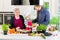 Dad, grandma and kid cooking together in kitchen