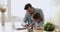 Dad helping cute small kid daughter doing homework at home