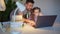 Dad helps daughter with online lessons on laptop