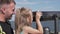 Dad helps her little daughter look through binoculars on the observation deck in the summer while traveling