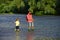 Dad and his child son are fishing on sky background. Old and Young. Happy father and son fishing in river holding