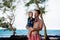 Dad, holding little toddler boy with binoculars, observing dolphins