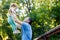 Dad holds baby daughter in his arms high in park