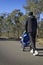 Dad jogging with baby stroller on a country road