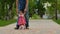 Dad leads little baby on way to park. Kid learns to walk. Parent with child on walk