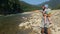 Dad with a little daughter is walking near a mountain river. Traveling with children