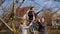 Dad, mom and daughter prune trees in the garden with scissors. The girl helps her parents standing on a stepladder. The concept of