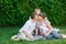 Dad mom and son sitting on a blanket in the park and kiss