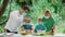 Dad and mom teach children how to cook grilled meat. Family in medical masks on a picnic in nature. recreation during the covid-19