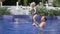 Dad plays with his little daughter in the outdoor pool