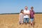 Dad with pre-teen son and daughter, full length portrait, Caucasian single father with two kids standing on wheat field at summer