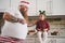 Dad in Santa hat and tattooed arms soothes upset daughter with elf hoop on head.Human Relationship concept. Daughter sitting on a