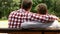 Dad and son embracing, sitting on bench in park, relations of support and trust