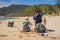 Dad and son in gloves cleaning up the beach pick up plastic bags that pollute sea. Natural education of children