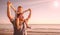 dad with son on his shoulders looking at the horizon in the water at the sea