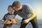 Dad and son launch a ship on the radio. Father shows the boy how to play with the boat on the remote control. The concept of