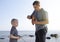 Dad and son launch a ship on the radio. Father shows the boy how to play with the boat on the remote control. The concept of