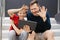 Dad and son make video call using tablet in the city on concrete staircase, cheerfully wave their hands saying hello