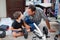 Dad and son are repairing a four-wheeled bicycle, a man shows a child how to drill, they smile and have fun while repairing