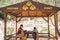 Dad and son sitting in community meeting point wooden hut in the mountains. School boy child and father taking rest in