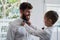 Dad taught me well on how to make a bowtie. an adorable little boy helping his father with his bowtie at home.