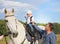 Dad teaches his son to sit in the saddle.