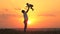 Dad tosses his happy daughter into blue sky at sunset. Father and healthy child play together, laugh and hug. Carefree