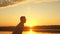 Dad tosses his happy little daughter in air on beach, having fun at sunset. father plays with child by water. happy