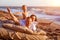 Dad tosses his son up. Lie on a bed by the sea at sunset.