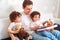 Dad with two daughters twins reading a book on the couch in the