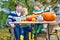 Dad and two little sons making jack-o-lantern for halloween in a