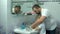 Dad washes a small child`s hands with soap over the sink with running water. Personal hygiene. Protection against coronavirus