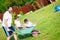 Dad in white driving his boys on the wheelbarrow