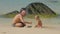 Daddy and cute boy build with wet sand on ocean beach