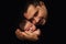 Daddy hugs his newborn baby. Father\'s love. Close-up portrait on a black background