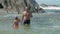 Daddy with small kid have fun in clear ocean water at cliffs