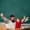 Daddy and son raising clenched fists in hooray gesture. Hooray. Family business. Chalkboard background. Family business