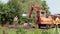 Daewoo industrial digger on work site. Male worker. Lifting arm moving