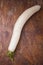 Daikon, east long white radish on brown background. Fresh organic vegan farm vegetables, seasonal harvest, healthy food