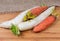 Daikon radish and carrot on wooden surface with sackcloth