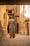 DAKHLA, EGYPT - FEBRUARY 8, 2019: Local man walking in a narrow street in Al Qasr village in Dakhla oasis, Egy